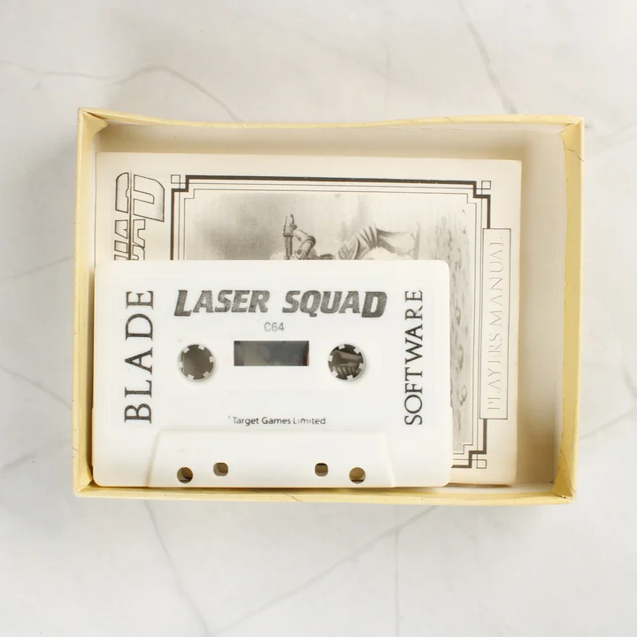 Laser Squad C64 kazetta és kézikönyv A Laser Squad fehér kazettája és kézikönyve a nyitott dobozban