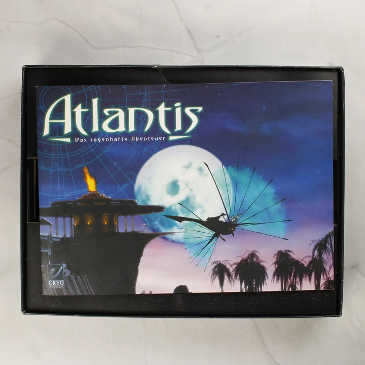 Atlantis kézikönyv a dobozban A nyitott Atlantis játékdoboz a benne lévő kézikönyvvel