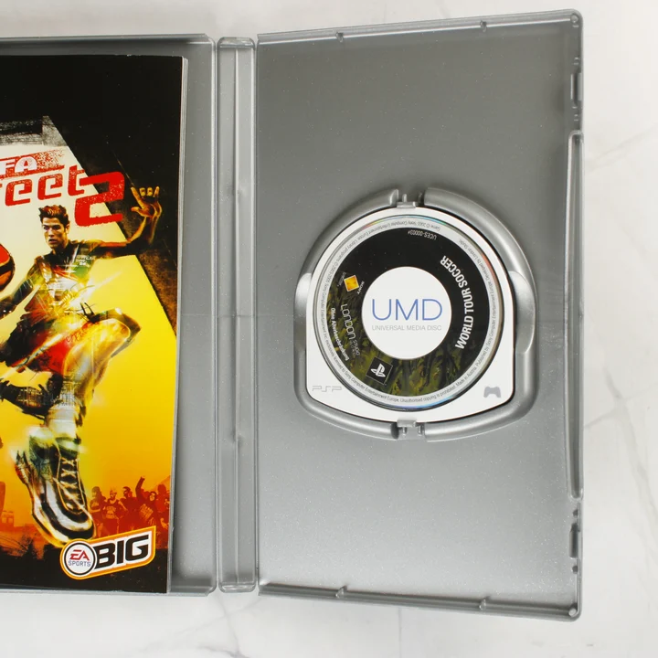 Nyitott PSP tok kézikönyvvel és eltérő UMD lemezzel