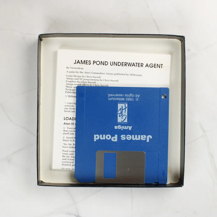 Nyitott Amiga játékdoboz floppy lemezzel és kézikönyvvel