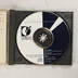 A nyitott tokban lévő fekete-fehér mintás CD lemez