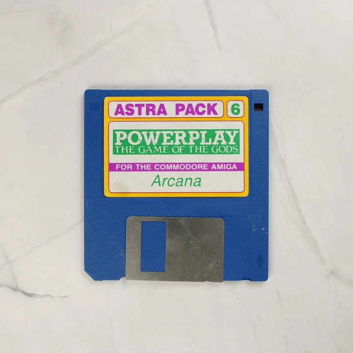 Kék színű 3,5 colos floppy lemez Powerplay: The Game of the Gods címkével