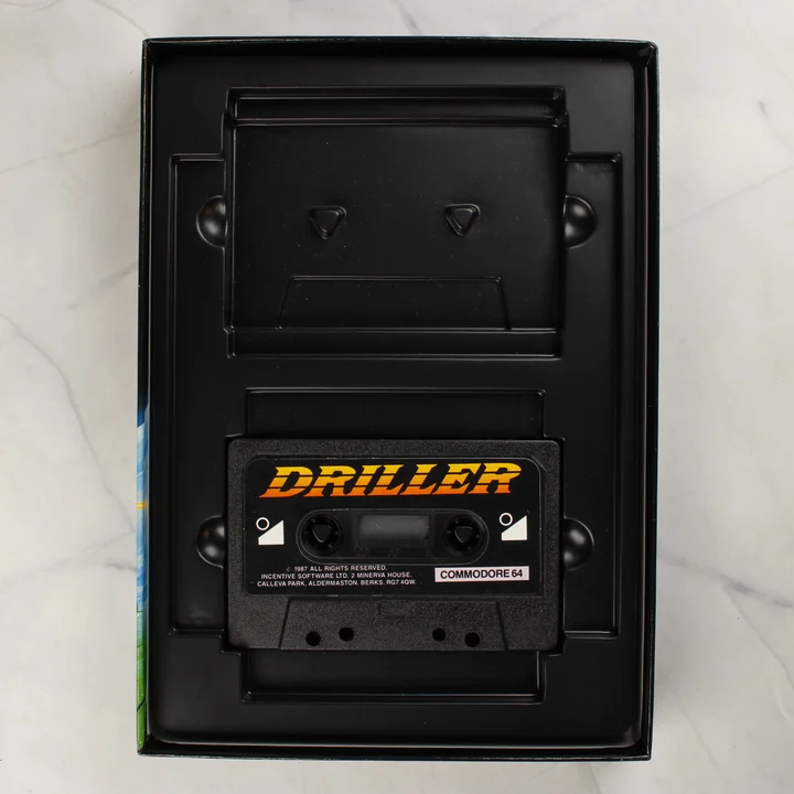 Driller Commodore 64 kazetta a belső tálcában Fekete műanyag kazetta a Driller játék feliratával a fekete belső tálcában