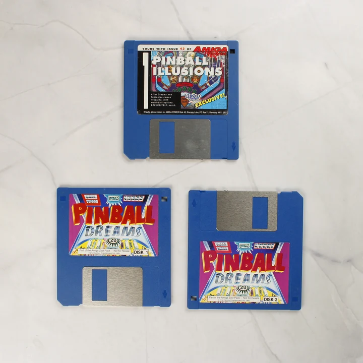 Pinball Dreams Amiga floppy lemezek Három darab kék színű 3,5 colos floppy lemez, köztük a Pinball Dreams és a Pinball Illusions lemezei