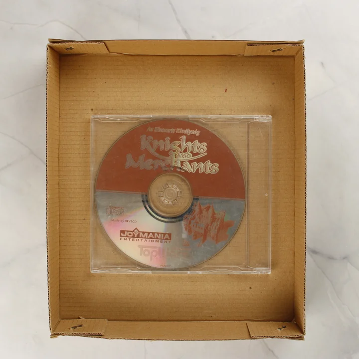 Knights and Merchants magyar nyelvű CD-lemez műanyag tokban, a belső barna karton tálcában elhelyezve