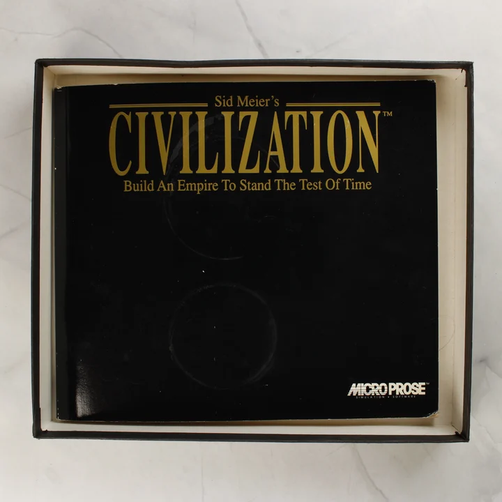 A Sid Meier's Civilization játék fekete borítójú kézikönyve a nyitott dobozban