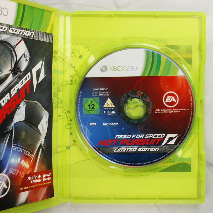 Need for Speed Hot Pursuit Limited Edition Xbox 360 nyitott tok lemezzel A nyitott Xbox 360 tok a Need for Speed Hot Pursuit Limited Edition játéklemezzel és a kézikönyv szélével