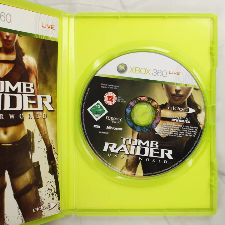 Nyitott Xbox 360 tok a Tomb Raider Underworld játéklemezzel és a kézikönyv szélével