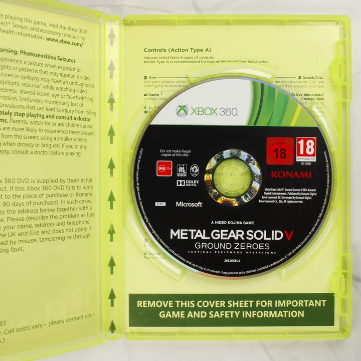 Metal Gear Solid V Ground Zeroes Xbox 360 belső lemez A nyitott Xbox 360 tok a Metal Gear Solid V Ground Zeroes játéklemezzel és az útmutatóval