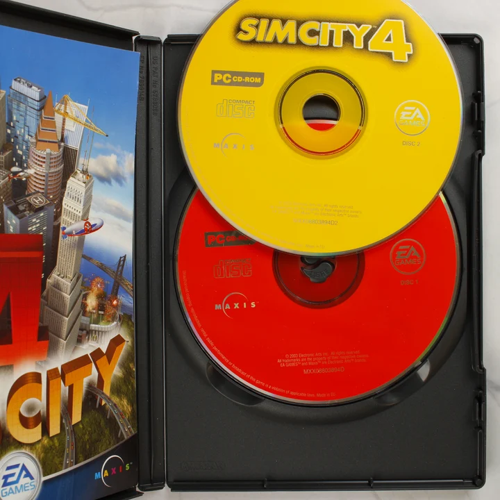 A SimCity 4 játék nyitott tokja a piros és sárga CD-ROM lemezekkel, valamint a kézikönyvvel