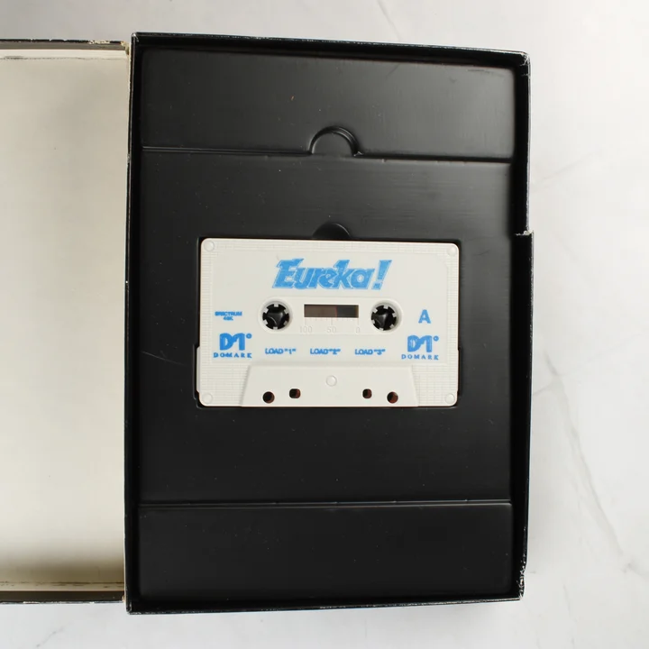 Fehér magnókazetta a fekete műanyag tartóban Eureka! felirattal.