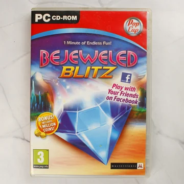 A Bejeweled Blitz PC-s videójáték tokjának előlapja a kék drágakővel és a PEGI 3 logóval