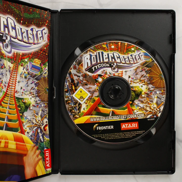 RollerCoaster Tycoon 3 PC játék belső A nyitott tok a RollerCoaster Tycoon 3 CD-ROM lemezzel és a kézikönyvvel