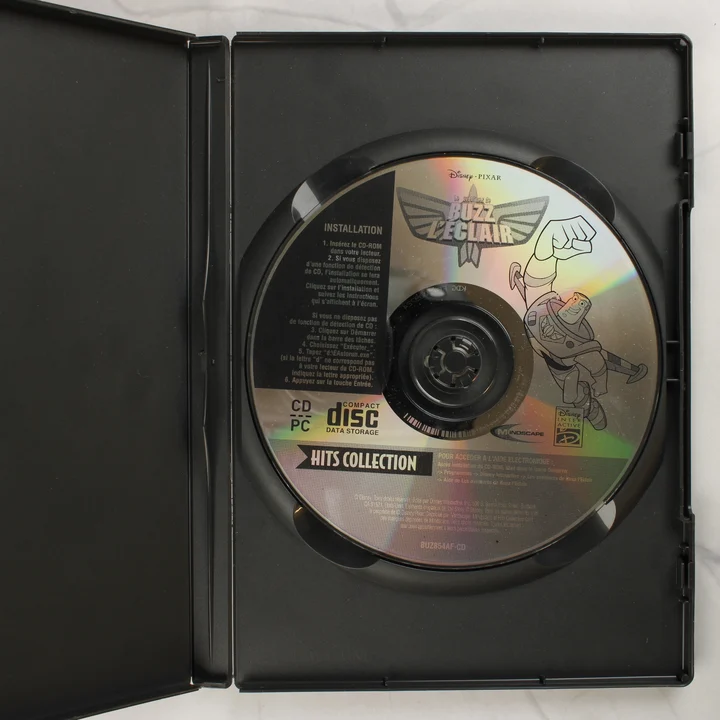 A Les aventures de Buzz L'Éclair eredeti CD-ROM lemeze a nyitott tokban
