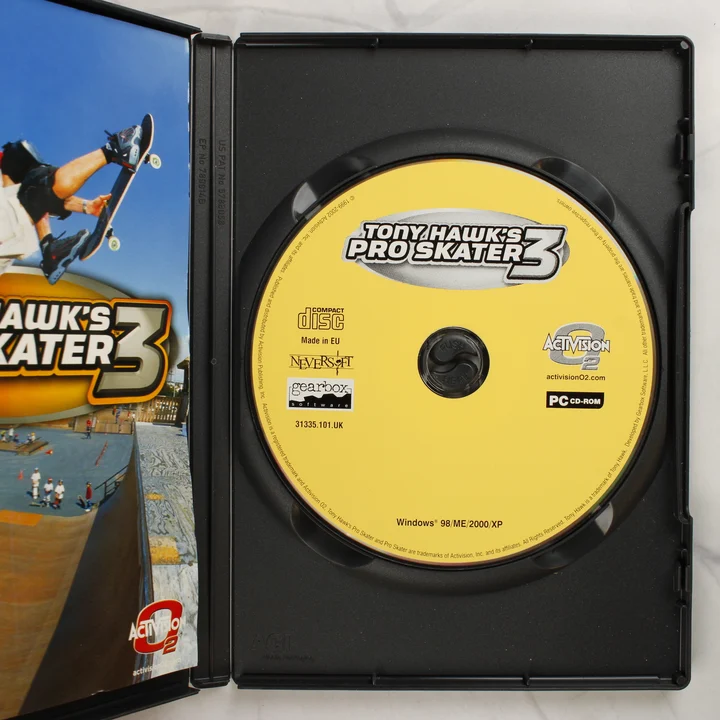 A nyitott tok a sárga CD-ROM lemezzel és a kézikönyv szélével