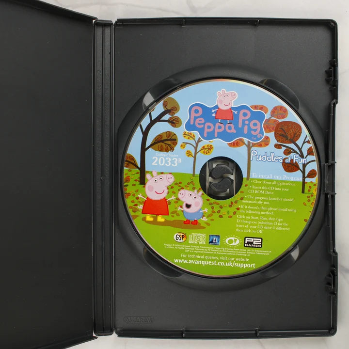 Peppa Pig: Puddles of Fun CD-ROM lemez a tokban A Peppa Pig: Puddles of Fun színes CD-ROM lemeze a nyitott fekete műanyag tokban