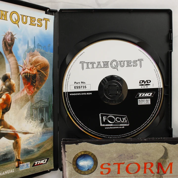 A nyitott Titan Quest játék tok a DVD-ROM lemezzel és a kézikönyvvel