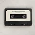 A Karakterszerkesztő szoftvert tartalmazó fekete magnókazetta fehér címkével