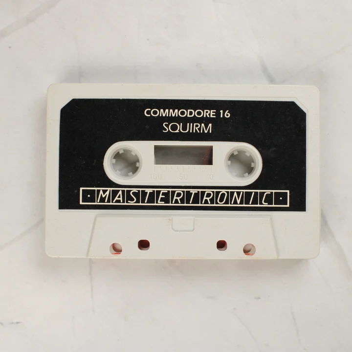 A Squirm játék szürke színű Commodore 16 kazettája fekete címkével