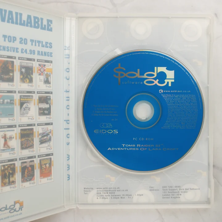 Tomb Raider III PC CD-ROM lemez és nyitott tok Kinyitott műanyag tok a kék színű Tomb Raider III PC CD-ROM lemezzel és a füzettel