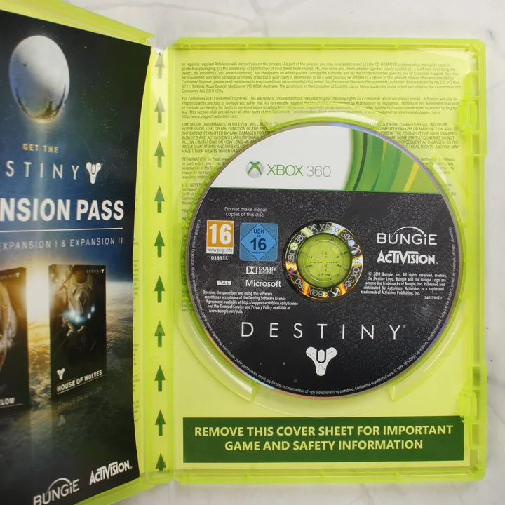 Nyitott Xbox 360 játéktok a Destiny lemezzel és a behelyezett füzettel