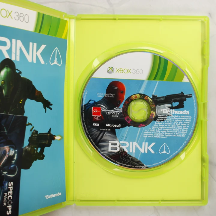 A Brink Special Edition Xbox 360 nyitott tokja a játéklemezzel és a füzettel