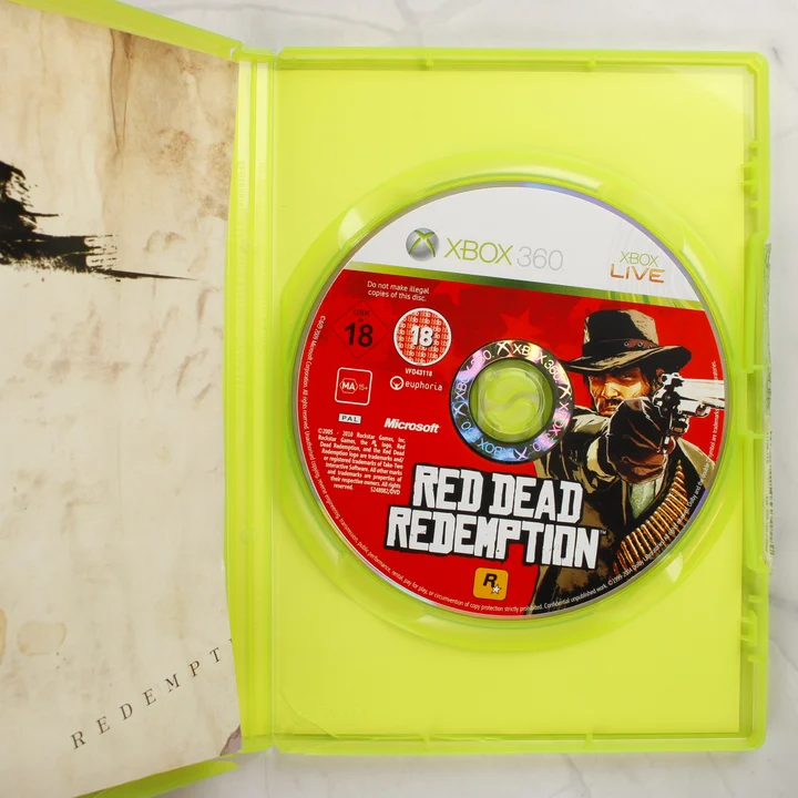 Red Dead Redemption Xbox 360 nyitott tok a lemezzel A Red Dead Redemption Xbox 360 nyitott tokja a lemezzel és a füzettel