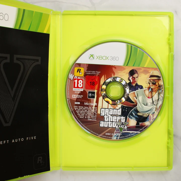 Nyitott Xbox 360 tok a Grand Theft Auto V játéklemezzel és füzettel