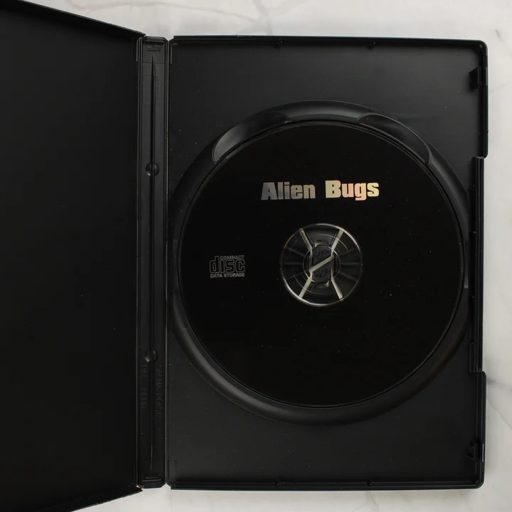 Nyitott fekete műanyag tok benne az Alien Bugs PC CD-ROM lemezzel