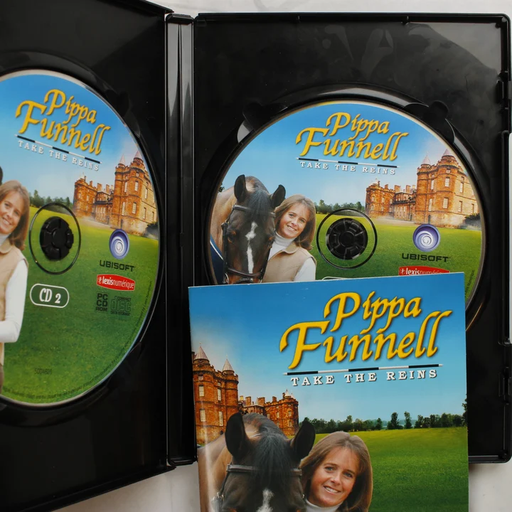 Pippa Funnell Take The Reins nyitott tok a lemezekkel és füzettel A kinyitott műanyag tok a két PC CD-ROM lemezzel és a kézikönyvvel