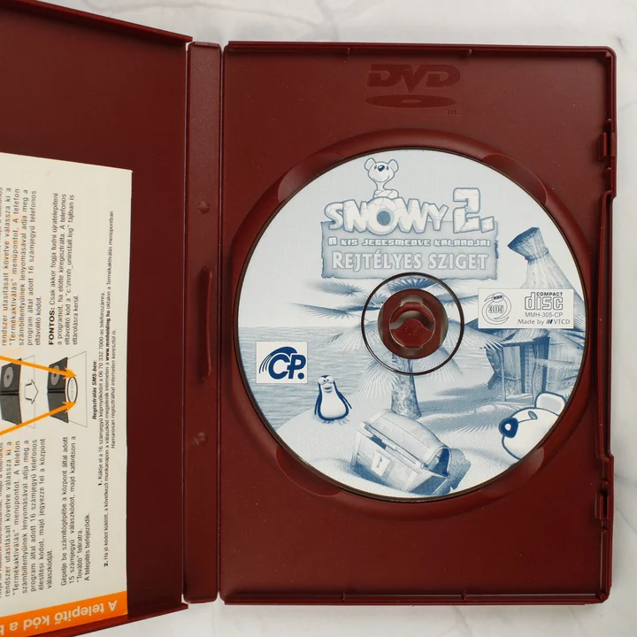Snowy 2. Rejtélyes sziget kinyitott tok és CD lemez A Snowy 2. Rejtélyes sziget kinyitott tokja a CD-ROM lemezzel és a füzettel