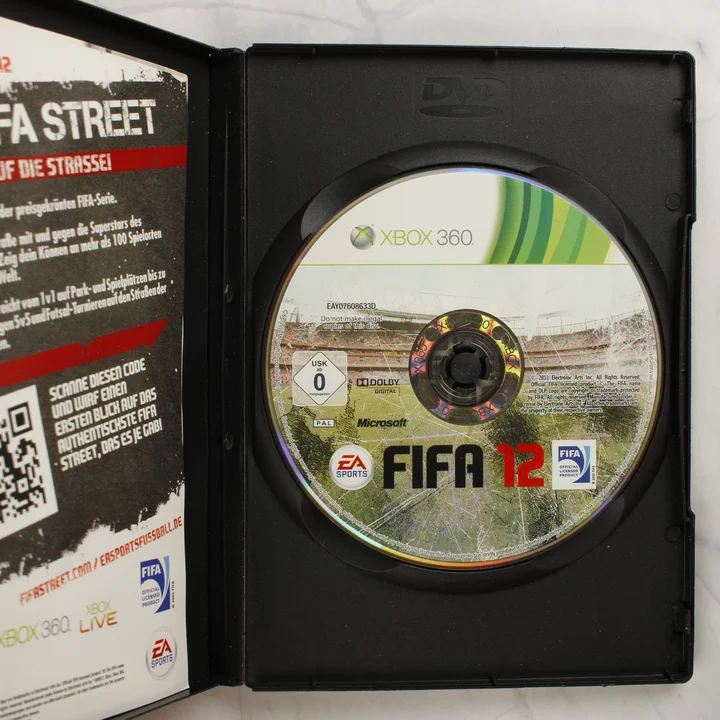 FIFA 12 Xbox 360 kinyitott tok a lemezzel A FIFA 12 Xbox 360 kinyitott tokja a játéklemezzel és melléklettel
