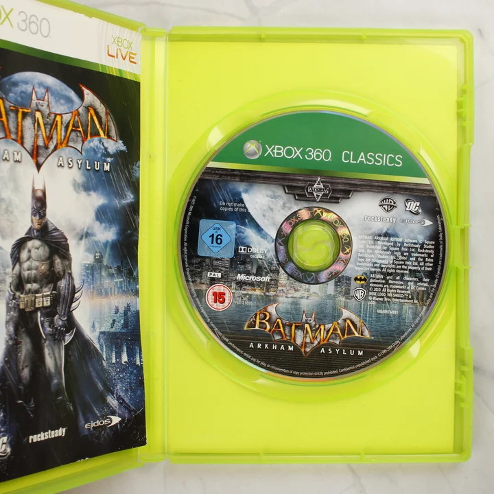 Nyitott Xbox 360 tok a Batman Arkham Asylum játéklemezzel és kiskönyvvel