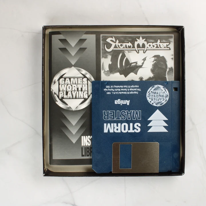 A Storm Master nyitott doboza kézikönyvvel és 3,5 colos floppy lemezzel
