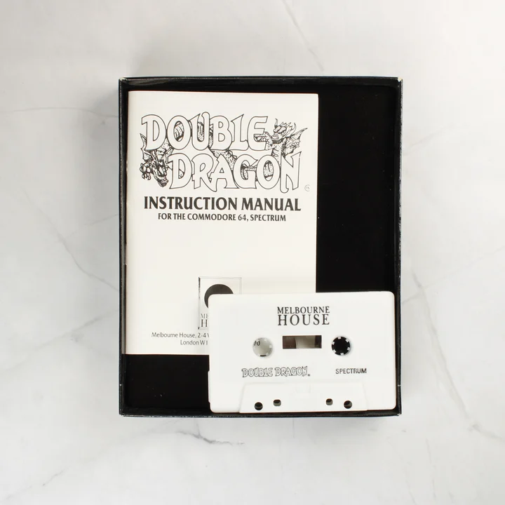 A Double Dragon játék fehér kazettája és a használati útmutató a dobozban