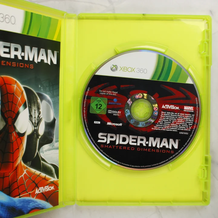 A Spider-Man: Shattered Dimensions nyitott Xbox 360 doboza a lemezzel és a füzettel
