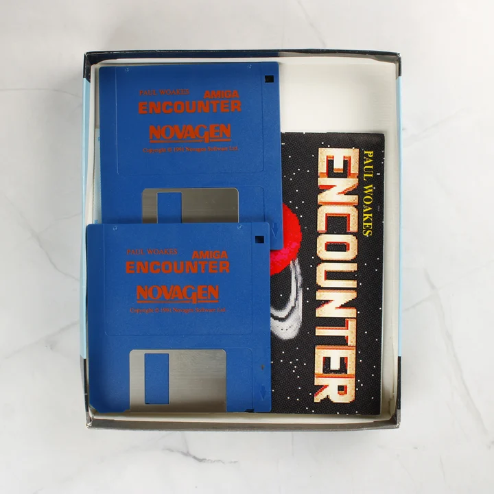 Két kék floppy lemez és egy kézikönyv az Encounter játék dobozában