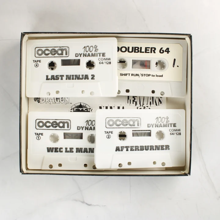 100% Dynamite játékkazetták A 100% Dynamite válogatás négy darab fehér kazettája a dobozban