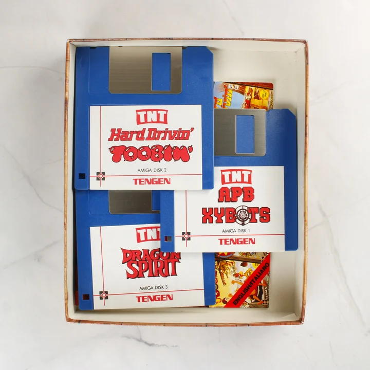 Három kék Amiga floppy lemez a TNT válogatás játékaival