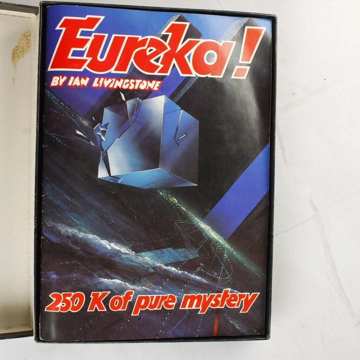 Eureka! kísérőfüzet Az Eureka! videójáték kísérőfüzetének színes borítója a dobozban.