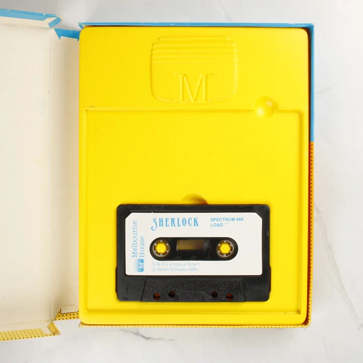 A nyitott doboz belseje a sárga tálcával és a magnókazettával