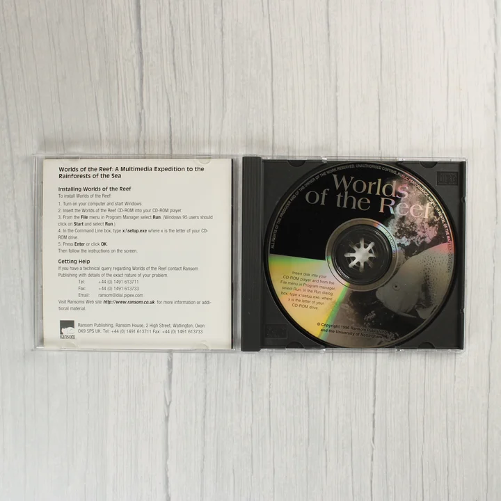 Nyitott CD-tok a lemezzel és a használati útmutatóval