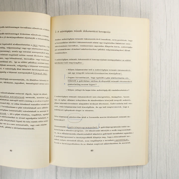 Nyitott könyvoldalak szöveggel és tollal tett jelölésekkel