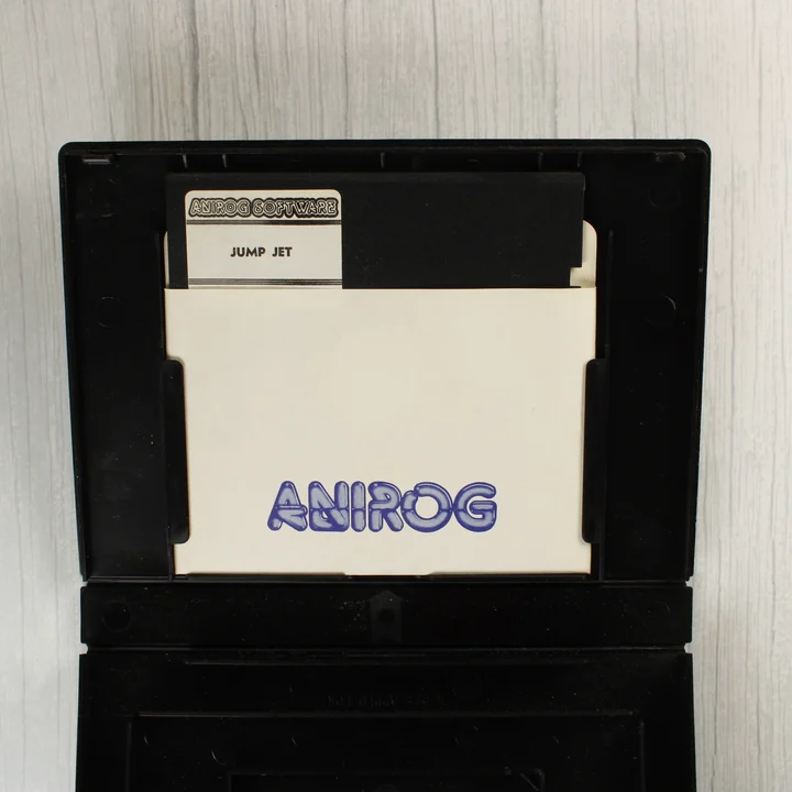 Nyitott fekete tok, benne az 5,25 colos floppy lemez fehér papírtokban.