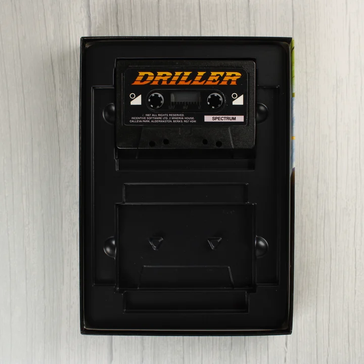 A Driller játék fekete magnókazettája a belső tálcában