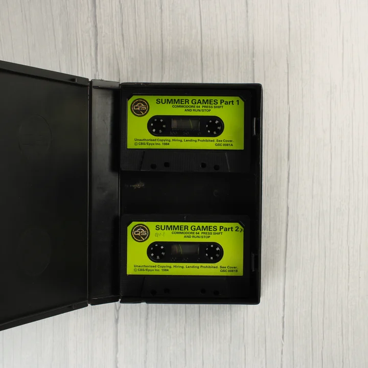 Nyitott tok két sárga címkés Commodore 64 kazettával